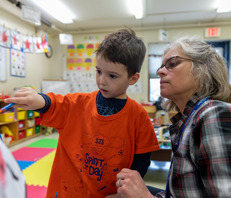  St. John pre-kindergarten aide Jodi Paulin with student