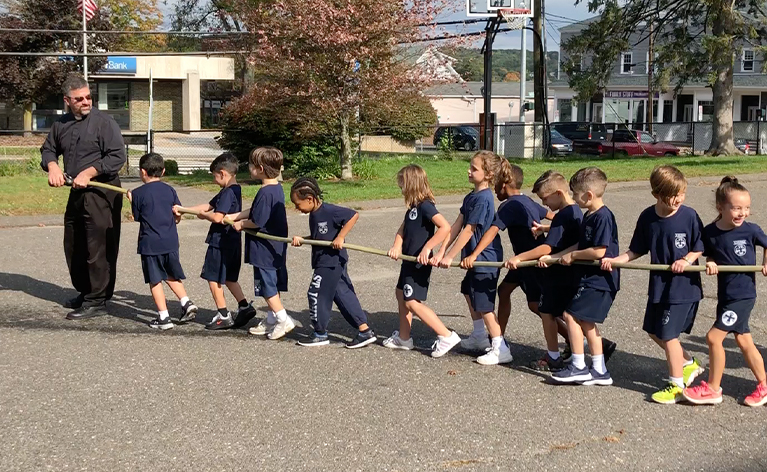 St. John students playing tug of war together with a rope outside